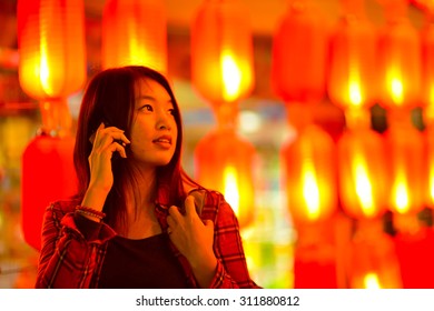 Chinese Teenager With Cell Phone Near Chinese New Year Lanterns