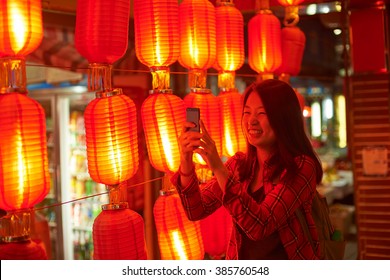 Chinese Teenager With Cell Phone Near Chinese New Year Lanterns