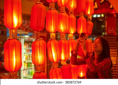 Chinese Teenager With Cell Phone Near Chinese New Year Lanterns