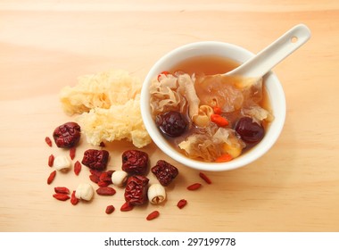 Chinese traditional white fungus or snow fungus soup over wooden table background with the raw ingredients