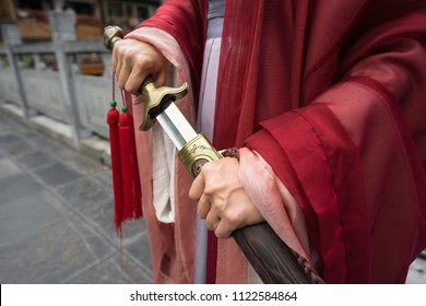 Chinese Warrior Drawing Sword, Signature Traditional Costume. Close Up Photo.