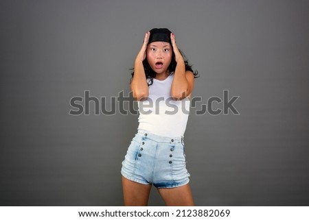 chinese woman with hands on head and shocked expression