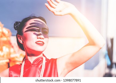 Chinesische Frau hält Hand hoch, um sich in heißen Sommertagen vor Sonnenlicht zu schützen.