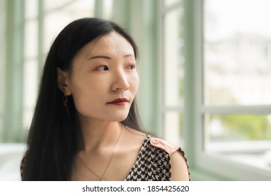 A Chinese Woman Looking Out A Window Inside A Sitting Room Within The Walters Art Museum In Baltimore Maryland.