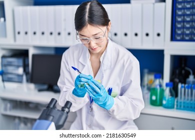 Chinese Woman Scientist Writing On Test Tube At Laboratory