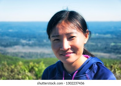 A Chinese Woman Standing On Top Of Bear Mountain In Salisbury Connecticut On A Sunny Day.