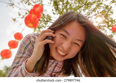 Chinese Woman Talking On Cell Phone During Chinese New Year