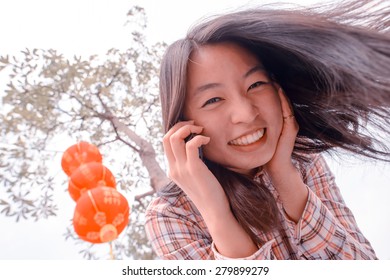 Chinese Woman Talking On Cell Phone During Chinese New Year