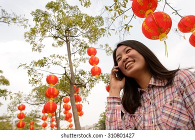 Chinese Woman Talking On Cell Phone During Chinese New Year