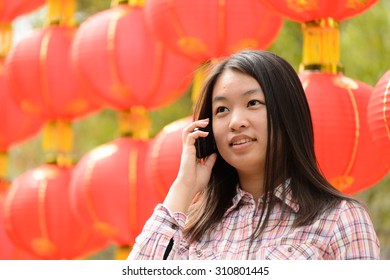 Chinese Woman Talking On Cell Phone During Chinese New Year