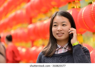 Chinese Woman Talking On Cell Phone During Chinese New Year