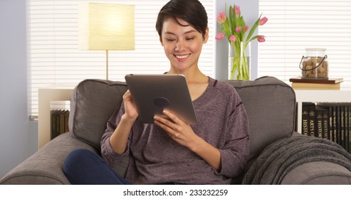 Chinese Woman Using Tablet On Couch