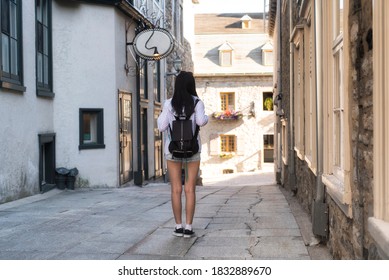 A Chinese Woman Walking Down A Narrow Alleyway Near The Place Paris In The Old Port Area Of Quebec City, Canada.