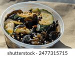 chinese woodear mushroom and cucumber salad (spicy restaurant appetizer side dish food in plastic take  out container) takeaway takeout take away asian wood ear