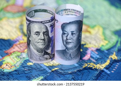 Chinese Yuan And US Dollars On The Map Of China. Concept Of Political Conflict Over Taiwan