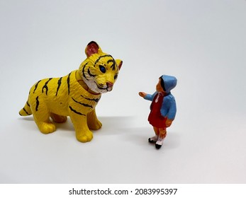 Chinese Zodiac Sign Year of Tiger.Happy Chinese New Year, Year of the Tiger. A miniature of a tiger and a little girl on a white background.