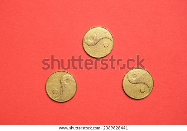 I Ching\
ancient Chinese oracle, Book of Changes or Classic of Changes. Old\
coins close-up on red background.\
