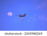 Chinook during firefight flight with moon background  