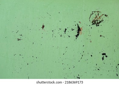 Chipped green paint and scratches on glass surface. Abstract grunge background.