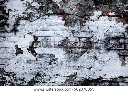 Chipped and peeling white paint on the surface of the old brick wall. Cracked, crumbled grunge texture with watercolor effect. Vintage background.