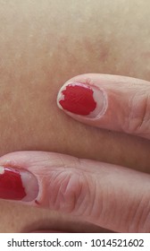 Chipped Red Nail Polish On Woman's Fingers.