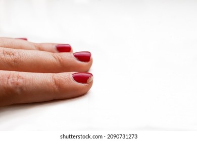 Chipped Red Nail Polish On Woman's Index Finger