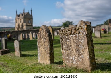 Chipping Campden, UK. August 2021. Graveyard Of The Church Of St James, With View Over The Cotswold Hills In Gloucestershire. The Building Beyond The Cemetery Is Jacobean Era East Banqueting House.