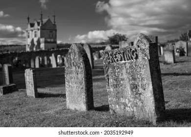 Chipping Campden, UK. August 2021. Graveyard Of The Church Of St James, With View Over The Cotswold Hills In Gloucestershire. The Building Beyond The Cemetery Is Jacobean Era East Banqueting House.