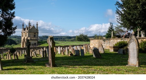 Chipping Campden, UK. August 2021. Graveyard of the Church of St James, with view over the Cotswold hills in Gloucestershire. The building beyond the cemetery is Jacobean era East Banqueting House.