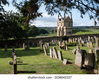 Chipping Campden, UK. August 2021. Graveyard Of The Church Of St James, With View Over The Cotswold Hills In Gloucestershire. The Building Beyond The Cemetery Is Jacobean Era East Banqueting House.