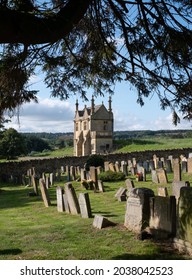 Chipping Campden, UK. August 2021. Graveyard Of The Church Of St James, With View Over The Cotswold Hills In Gloucestershire. The Building Beyond The Cemetery Is Jacobean Era East Banqueting House.