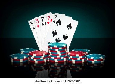 Chips And Cards On Black Table. Playing Cards In Poker Game With Full House Or Full Boat Combination. Successful And Win In Casino