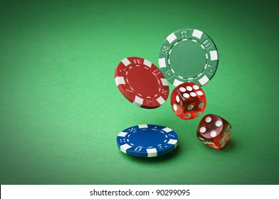 Chips and dices on green background close up