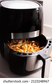 Chips or french fries made in tendy kitchen gadget air fryer, small countertop convection oven, deep fast frying oil free, more healthful way to cook deep-fried food - Shutterstock ID 2123248967