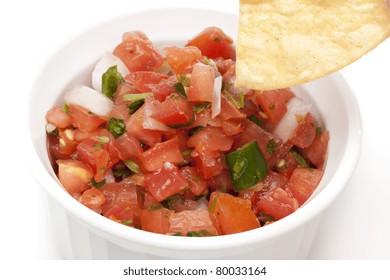 Chips And Fresh Salsa In A Bowl Against A White Background