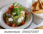 chips and guacamole on a white marble background