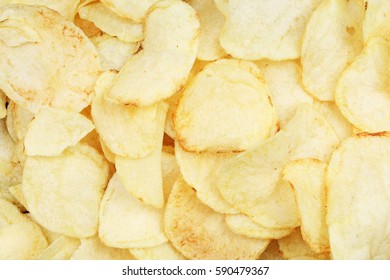 Chips pattern. Yellow salted potato chips as background. Chips texture studio photo.
