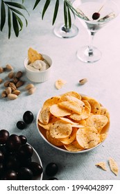 The chips are in a plate on the table. on the table are glasses with drinks, chips and grapes. - Shutterstock ID 1994042897