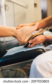 Chiropodist Fitting An Orthopedic Foot Insole To A Patient.