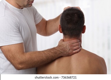 Chiropractic Back Adjustment. Muscular Man Suffering From Back And Neck Pain.