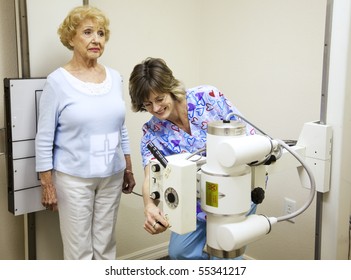 Chiropractic Nurse Prepares To X-ray A Senior Woman's Spine.