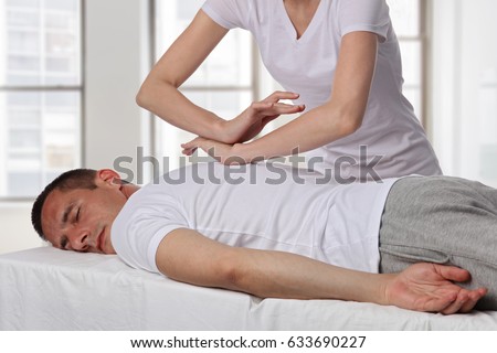 Chiropractic, osteopathy, manual therapy, acupressure. Therapist doing healing treatment on man's back. Alternative medicine, pain relief concept. Rehabilitation after Back Injury, Physical therapy.