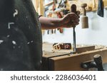 Chisel in use. Closeup shot of professional male carpenter holding one of his chisels to shape, carve and cut wood. High quality photo