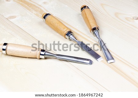 Chisels on a wooden background. Assortment of chisels of wood for carpentry. A set of tools for wood processing