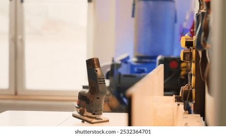 Chisels, screwdrivers, wrench and pliers on wall in furniture assembly shop next to electric router on workbench. Close up of woodworking gear on rack in joinery and power tool - Powered by Shutterstock