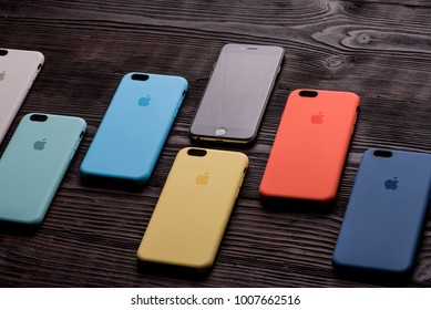 Chisinau, Moldova - January 23, 2018: Black IPhone With Six Different-colored Cases On Wooden Table