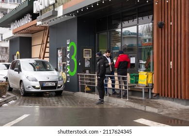 Chisinau, Moldova - January 23, 2022: McDonald's Drive. Cars Line Up On McDonald's Drive. Glovo Delivery Staff Is Waiting For The Order To Be Prepared.