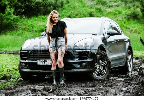 CHISINAU, MOLDOVA - JUNE 17, 2021:\
Porsche Macan S in off-road racing full of mood on bad road in\
Moldova. Strong fitness girl driving Porsche. Editorial\
photo.