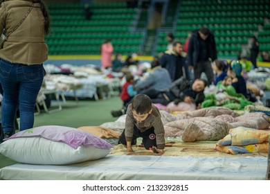 chisinau, moldova - march 4 2022: little ukrainian romani little boy playing on folding bad at chisinau arena refugee center