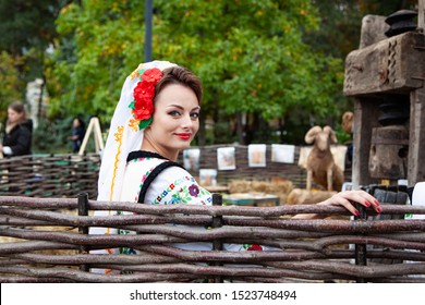 Chisinau, Moldova - October 5, 2019: Young women in traditional Balkanic costume at a festival in Chisinau, the capital of Moldova. Rest in the park is the central part of the city.